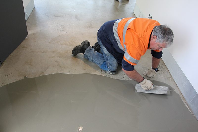 Applying a floor leveller to re-build the floor height after tile removal.